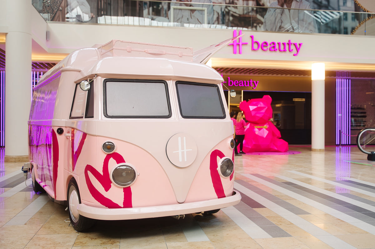 Pink and white branded VW truck at an H beauty retail location